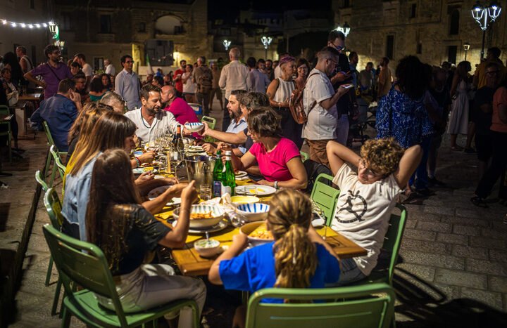 obrazek przedstawia włoską rodzinę jedzącą kolację na mieście